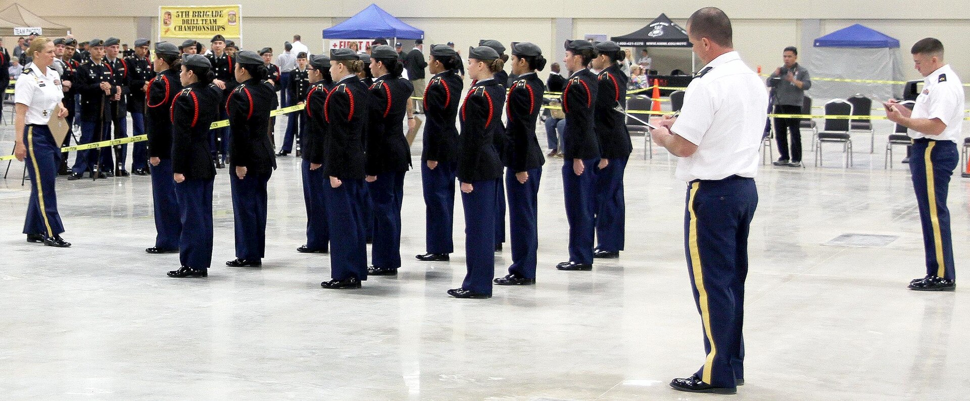 Junior ROTC cadets from San Antonio’s Ronald Reagan High School conclude their winning routine in the Unarmed Regulation Drill event during the 5th Brigade JROTC Drill Competition Feb. 6. Surrounding the formation are (from L to R) Master Sgt. Angela Cafferky, Sgt. Shawn Sarver, and Staff Sgt. Christian Hubbell, all NCOs assigned to Fort Sam Houston that served as judges for the competition.