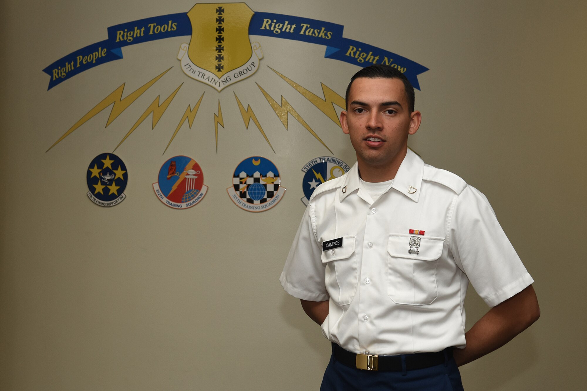 U.S. Army Pfc. David C. Campos, 312th Training Squadron student, stands next to a sign representing the 17th Training Group in Brandenburg Hall on Goodfellow Air Force Base, Texas, Feb. 5, 2016. Campos is the Goodfellow Student of the Month Spotlight for January, a series highlighting Team Goodfellow students. (U.S. Air Force photo by Staff Sgt. Laura R. McFarlane/Released)