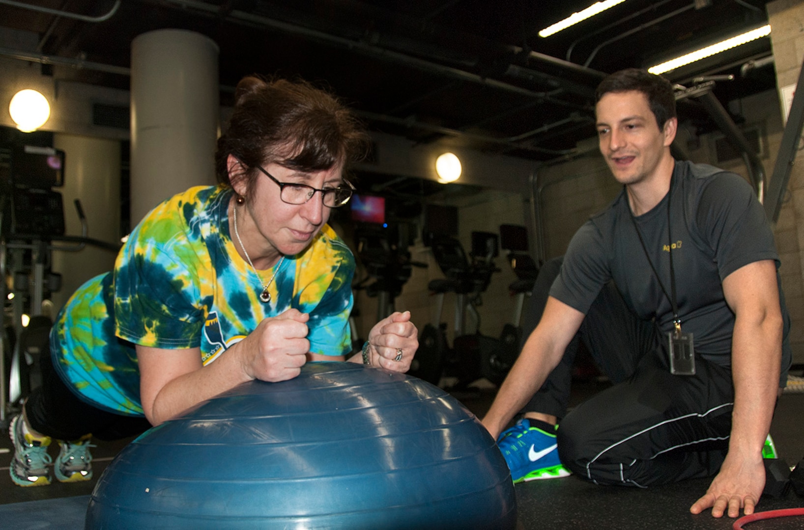 Lynn Thompson of DLA Logistics Operations works on core strength in a one-on-one workout with HQC Fitness Center coach Brandon Rudolph.