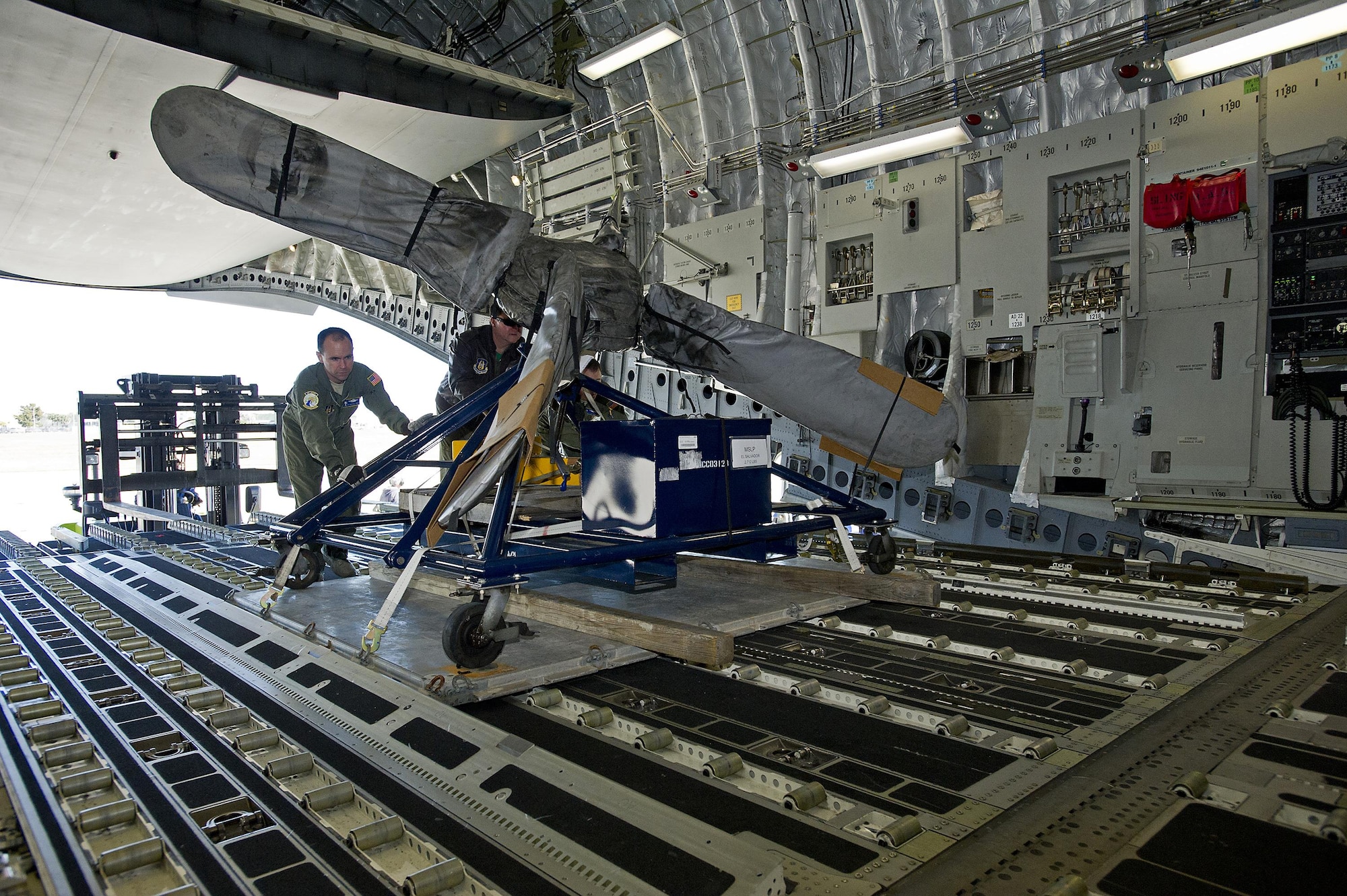 Tech. Sgt. Michael Smith, a loadmaster assigned to the 300th Airlift Squadron, Joint Base Charleston, South Carolina, pushes an aircraft propellar into the cargo area of a C-17 Globemaster III aircraft. Reservists assigned to the 300 AS assisted the U.S. Coast Guard with transporting several MH-65 Dolphin helicopters and various supplies Feb. 5-7, 2016. (U.S. Air Force photo by SSgt. Bobby Pilch)