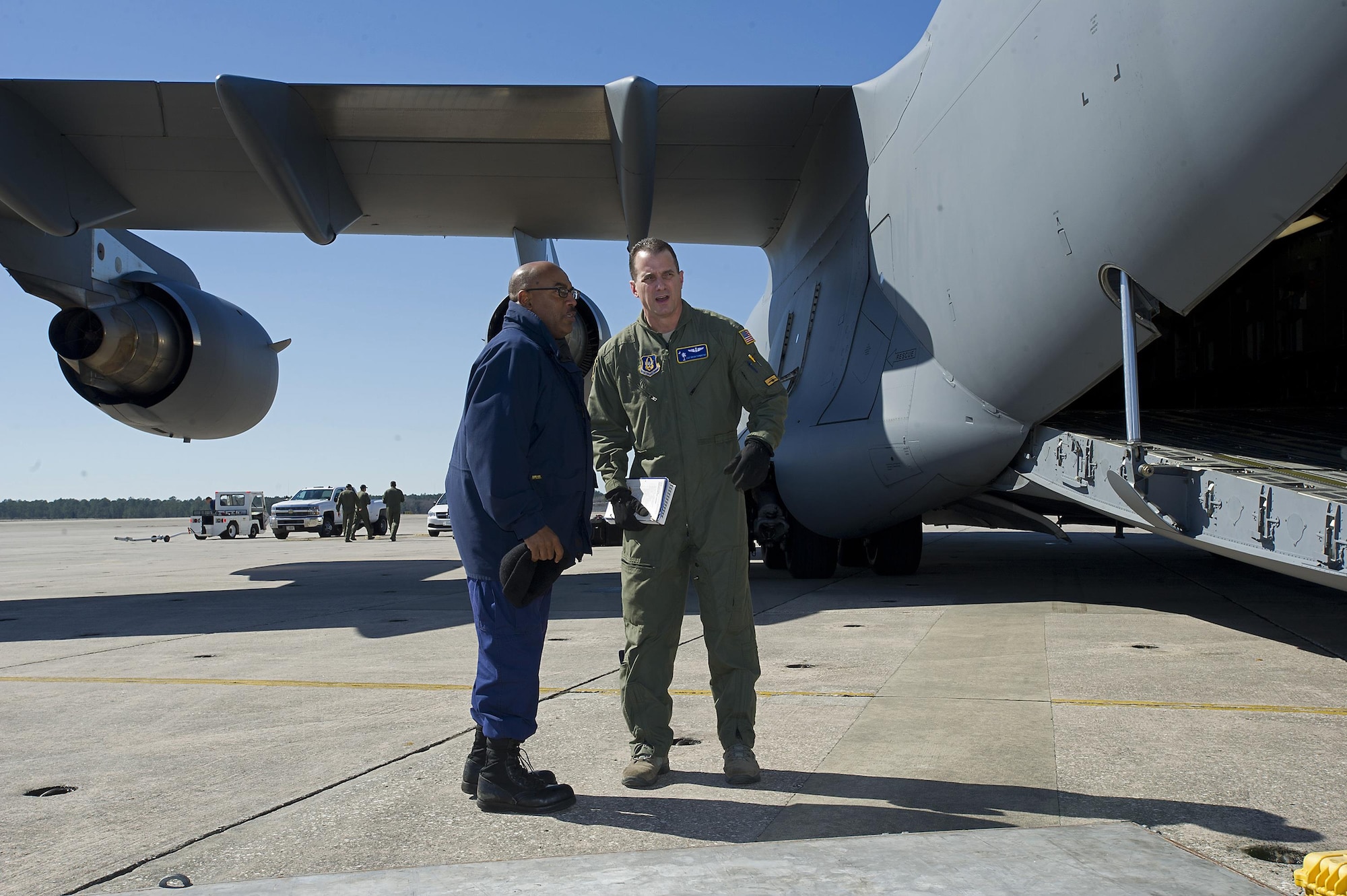 Tech. Sgt. Brian Farmintino (right), a loadmaster assigned to the 300th Airlift Squadron, Joint Base Charleston, South Carolina, discusses execution of loading cargo with Chief Warrant Officer Sherrod Younge with the U.S. Coast Guard.  Citizen Airment assigned to the 300 AS assisted the U.S. Coast Guard with transporting several MH-65 Dolphin helicopters and various supplies Feb. 5-7, 2016. (U.S. Air Force photo by SSgt. Bobby Pilch)