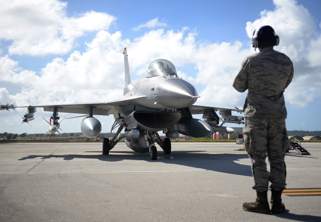 A crew chief assigned to the 35th Aircraft Maintenance Squadron, Misawa Air Base, Japan, prepares a F-16 Fighting Falcon, piloted by 1st Lt. Dave Takahashi, 13th Fighter Squadron, for takeoff Feb. 4, 2016, at Andersen Air Force Base, Guam.  Several F-16 Fighting Falcons from the 13th FS are deployed to Andersen AFB in support of Cope North 2016. Cope North is an annual event that focuses on humanitarian assistance and disaster relief and large force employment in an effort to enhance interoperability among forces from the U.S., Japan, Australia, South Korea, Philippines and New Zealand. (U.S. Air Force photo/Senior Airman Joshua Smoot)