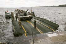 Marines with Bridge Company, 8th Engineer Support Battalion, prepare to unload two M1A1 Abrams tanks following their transport across New River by using a seven-bay raft system during a water-crossing operation at Marine Corps Base Camp Lejeune, N.C., Feb. 4, 2016. The unit boasts a wide range of raft systems and bridging equipment, which enables tactical vehicles to cross large bodies of water.