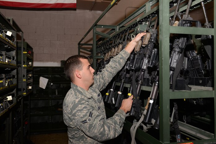 Airman 1st Class Dillon Goss, 99th Security Forces Squadron armorer, locks up a firearm in the armory at Nellis Air Force Base, Nev., Feb. 9, 2016. Weapons and ammunition kept within the armory walls are kept in separate containers that are constantly locked and under the close supervision of 99th SFS members. (U.S. Air Force photo by Airman 1st Class Nathan Byrnes)