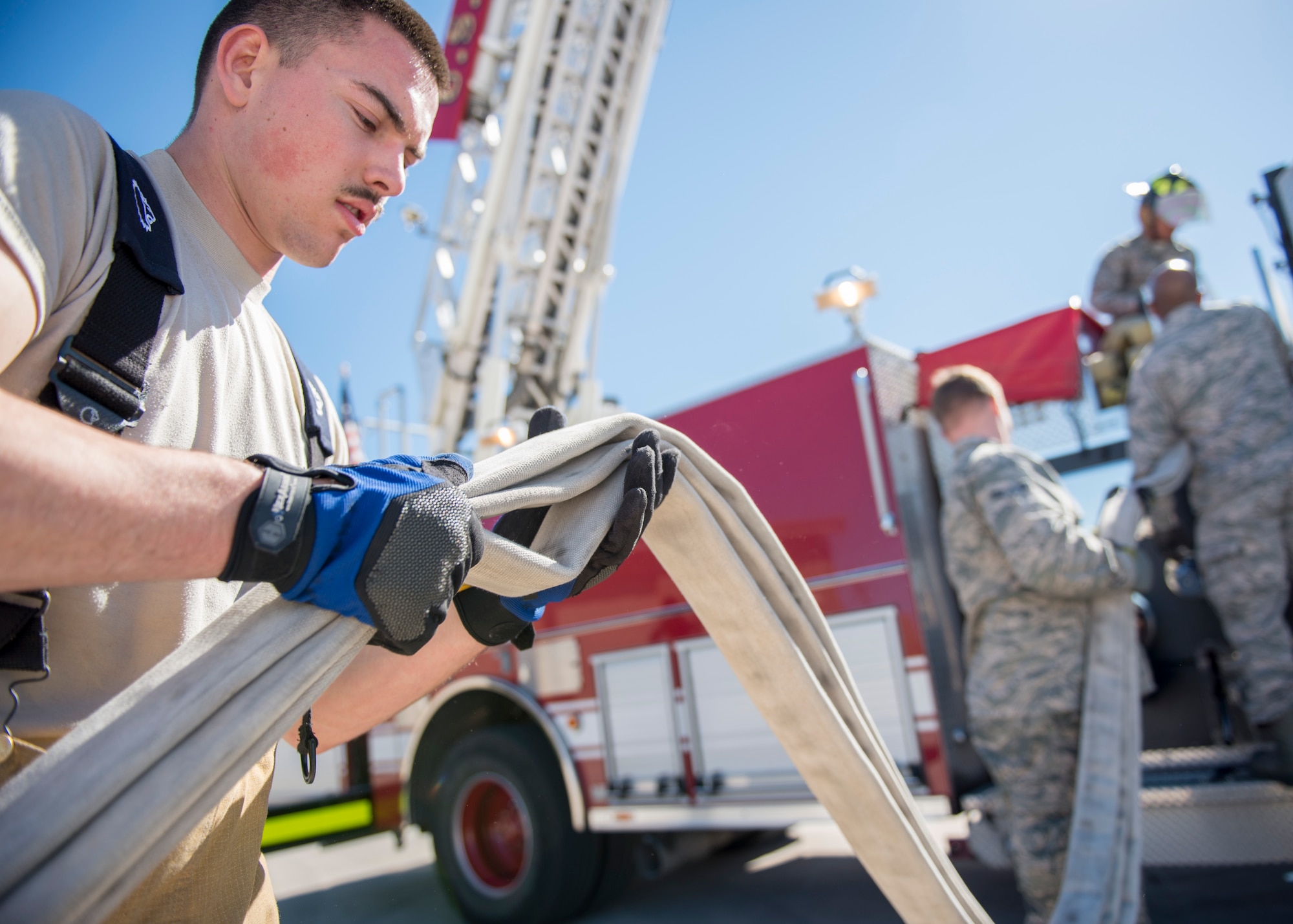 Airman Bryce Foslien, a 49th Civil Engineering Squadron fire protection specialist, helps roll up a hose during an exercise Feb. 9, at Holloman Air Force Base, N.M. These Airmen firefighters train year-round to remain prepared for when they are called upon. (U.S. Air Force photo by Airman 1st Class Randahl J. Jenson)