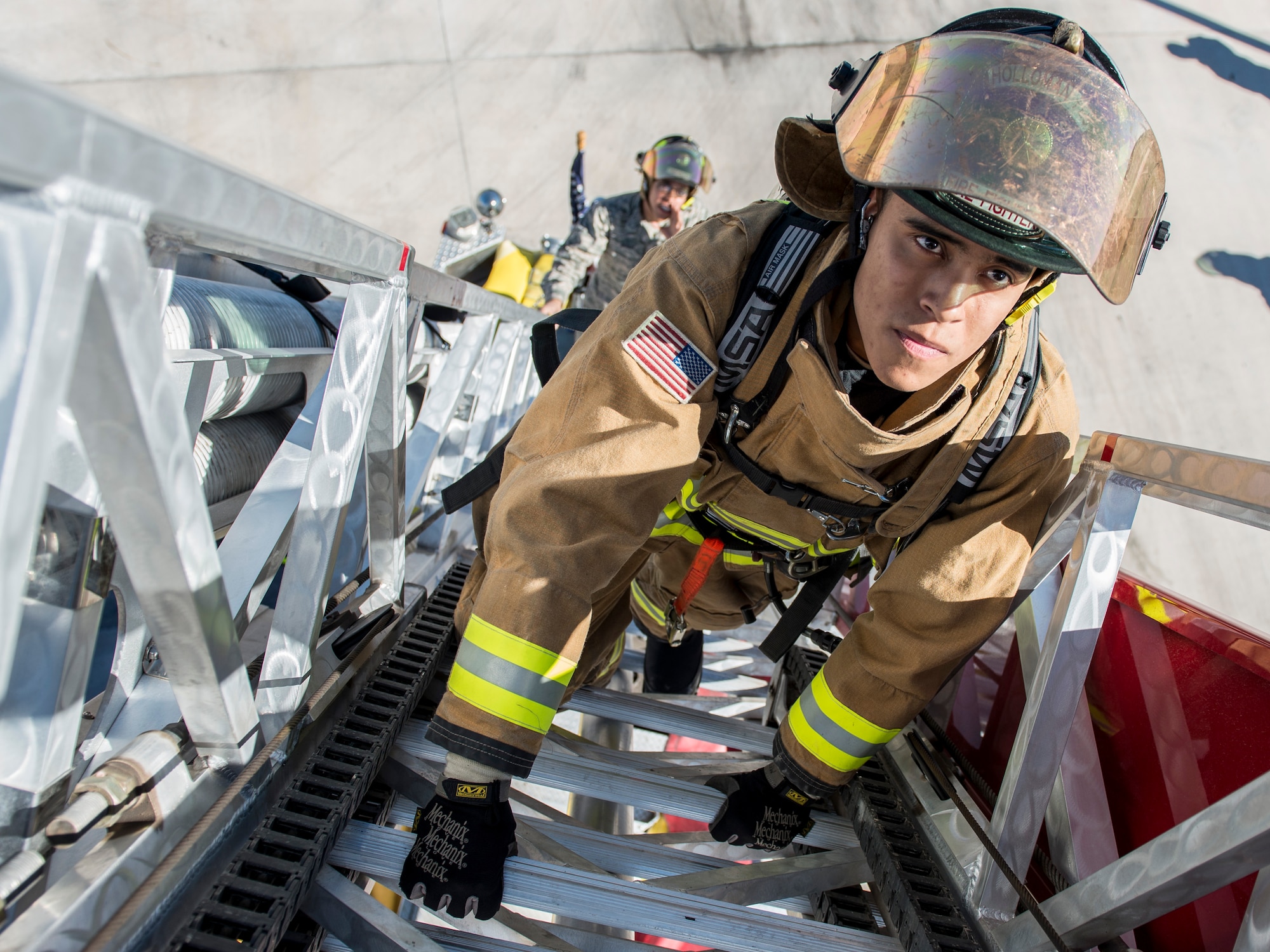 Airman 1st Class Justin Medina, a 49th Civil Engineer Squadron fire protection specialist, climbs an aerial ladder on a fire truck during an exercise Feb. 9, at Holloman Air Force Base, N.M. These Airmen firefighters are the first to respond to fire, bio-hazardous and chemical crises. (U.S. Air Force photo by Airman 1st Class Randahl J. Jenson)
