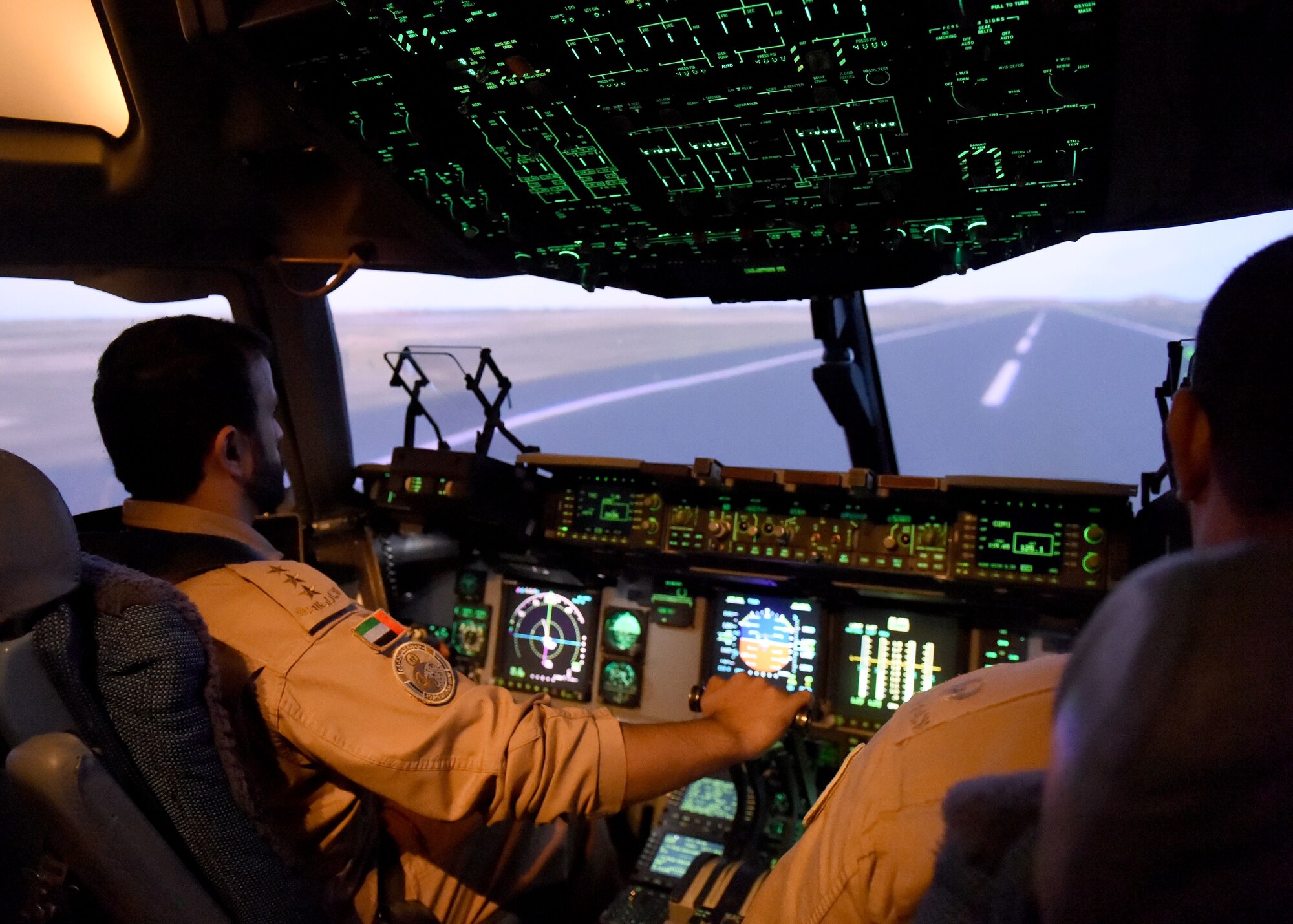 United Arab Emirate air force Capt. Abdulla Almehrezi, C-17 Globemaster III cargo aircraft instructor pilot trainee, operates a C-17 training simulator with United Arab Emirate Air Force Lt. Col. Hamdan Alnaqbi, C-17 instructor pilot trainee, Altus Air Force Base, Okla., Feb. 2, 2016. Training international students helps improve joint nation missions with uniformed knowledge and operations. (U.S. Air Force photo by Airman 1st Class Kirby Turbak)
