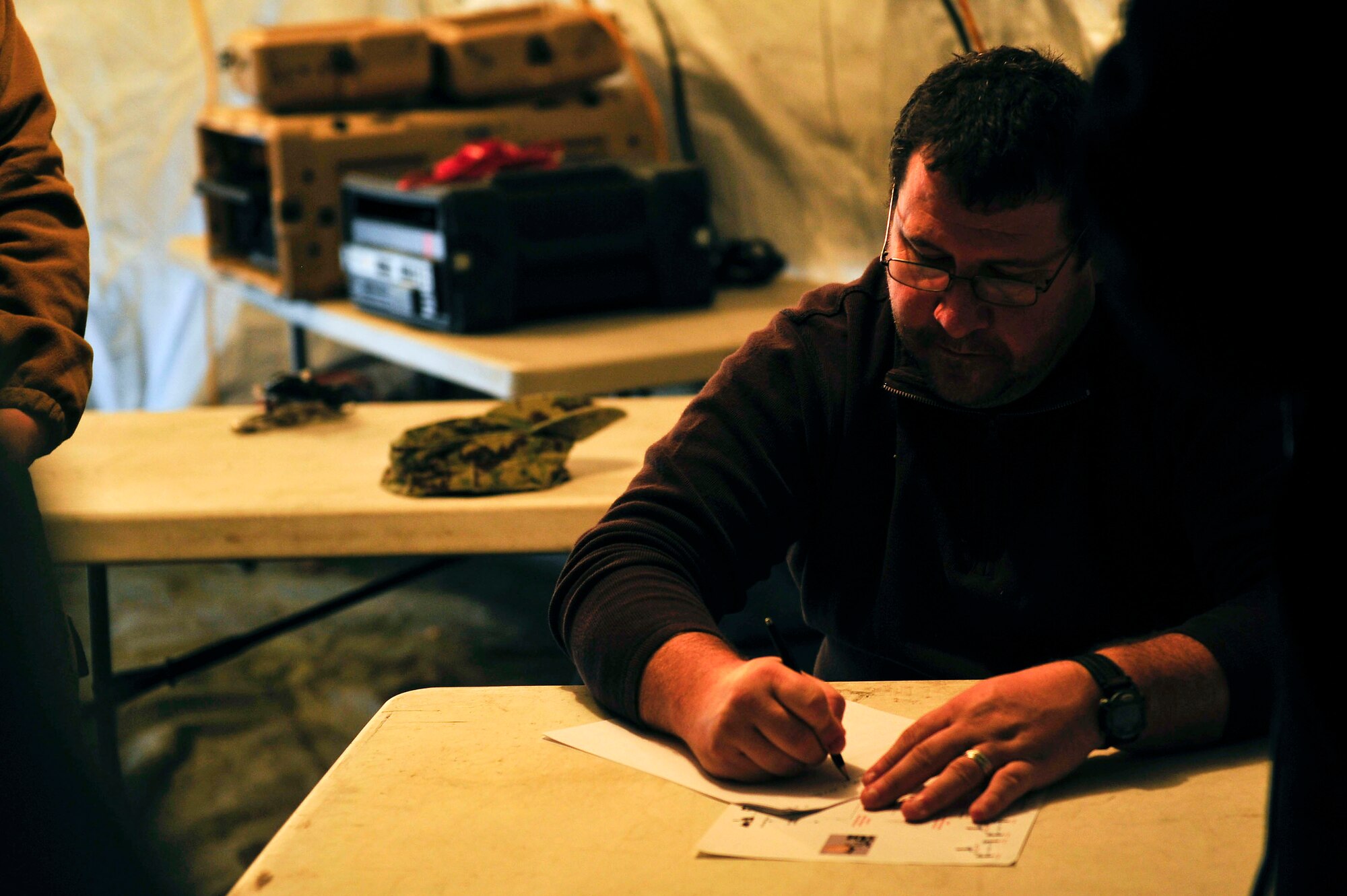 Christopher Peters, information systems manager for the 833rd Transportation Battalion, corresponds communication needs for a command post exercise at Fort Eustis, Va., Feb. 9, 2016. To ensure mission capability, Peters has to make sure the computers and telephones are connected properly to guarantee smooth operations. (U.S. Air Force photo by Airman 1st Class Breonna Veal)