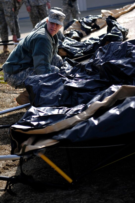 A U.S. Army Soldier from the 833rd Transportation Battalion prepares to lift a tent during a command post exercise at Fort Eustis, Va., Feb. 9, 2016. The exercise was designed to train the members of the brigade how to set up a fully operational command post used for crucial communication between command leaders.(U.S. Air Force photo by Airman 1st Class Breonna Veal)