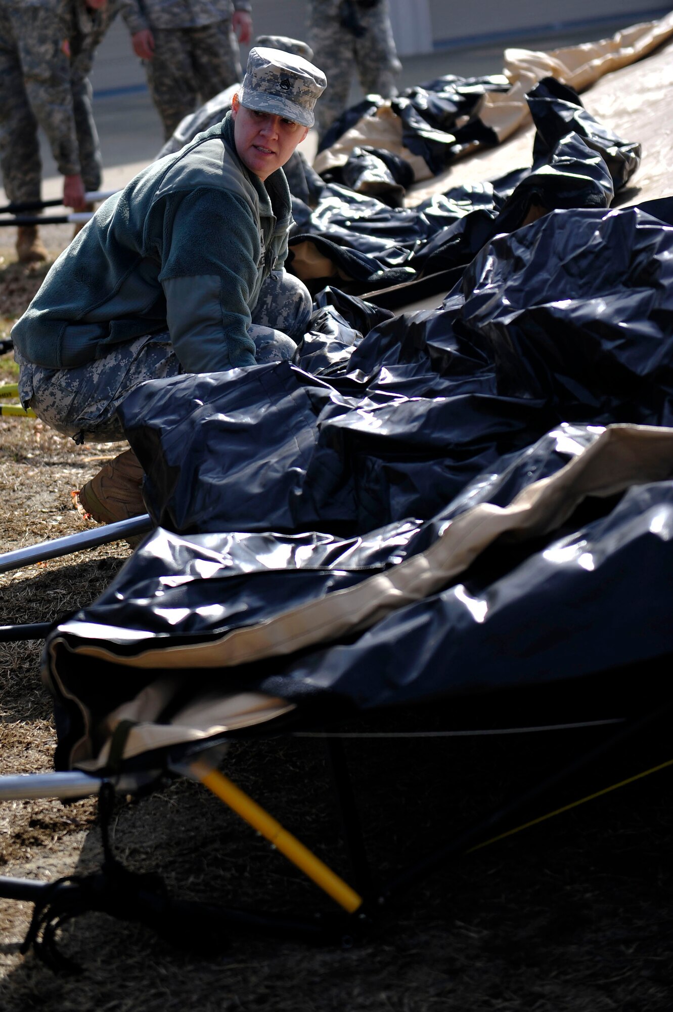 A U.S. Army Soldier from the 833rd Transportation Battalion prepares to lift a tent during a command post exercise at Fort Eustis, Va., Feb. 9, 2016. The exercise was designed to train the members of the brigade how to set up a fully operational command post used for crucial communication between command leaders.(U.S. Air Force photo by Airman 1st Class Breonna Veal)