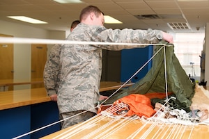 U.S. Air Force Staff Sgt. Kenneth McBride, Aircrew Flight Equipment (AFE) noncommissioned officer in charge of the parachute section, inspects a parachute gore at Langley Air Force Base, Va., Jan. 29, 2016. During the packing process, AFE technicians consistently check each other’s progress to ensure there are no rips, tears or discrepancies that could cause the parachute to malfunction. (U.S. Air Force photo by Airman 1st Class Derek Seifert)