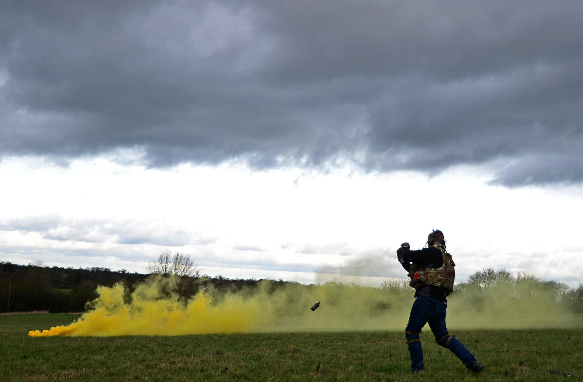 Staff Sgt. Joseph Bland, 56th Rescue Squadron special missions aviator, throws a smoke grenade during a combat search and rescue task force training exercise near Hinderclay, England, Feb. 4, 2016. Airmen assigned to the 56th and 57th RQSs performed various CSAR maneuvers to respond to a simulated threat scenario. (U.S. Air Force photo/Senior Airman Erin Trower)