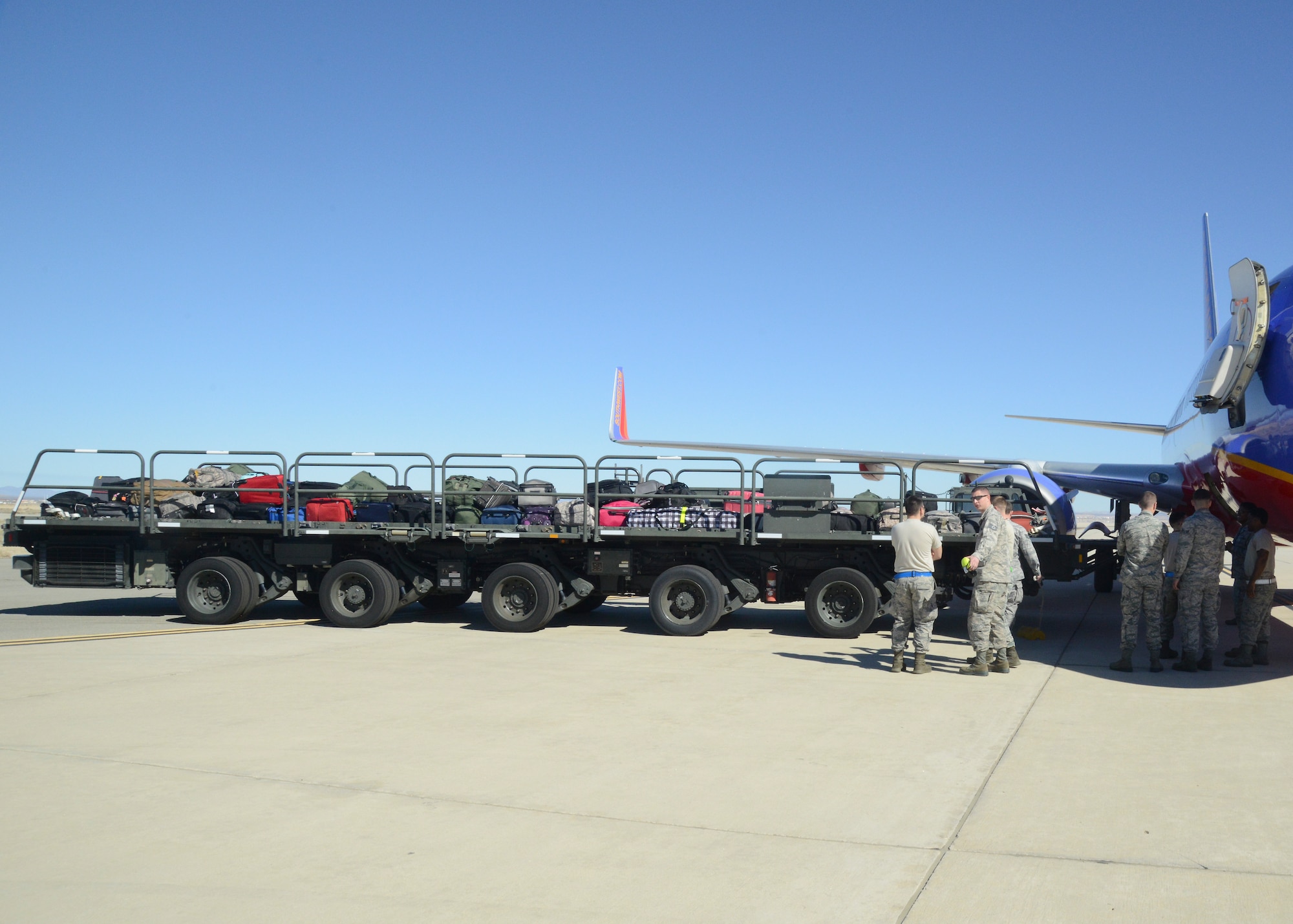 The luggage was transported by a 60,000-lbs k-loader from and manually loaded into the cargo bay. (U.S. Air Force photo by Kenji Thuloweit)
