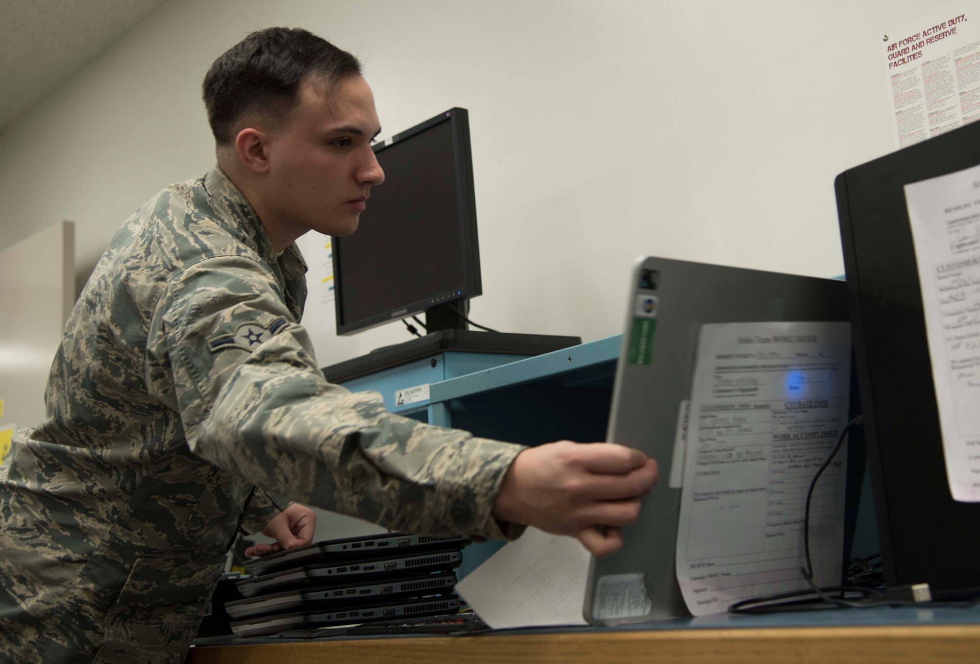 U.S. Air Force Airman Matthew Kennison, a client systems technician with the 35th Communications Squadron, sorts through a desk of electronics at Misawa Air Base, Japan, Feb. 10, 2016. The 35th CS back shop works on computers, laptops, tablets and phones brought into their office and at on-site locations.  (U.S. Air Force photo by Airman 1st Class Jordyn Fetter)