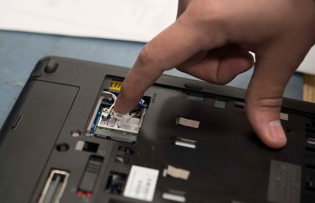 U.S. Air Force Airman Matthew Kennison, a client systems technician with the 35th Communications Squadron, removes a wireless card from a laptop computer at Misawa Air Base, Japan, Feb. 10, 2016. When laptops need access to the Secret Internet Protocol Router Network, client systems technicians remove the wireless cards, ensuring safety for classified information. (U.S. Air Force photo by Airman 1st Class Jordyn Fetter)