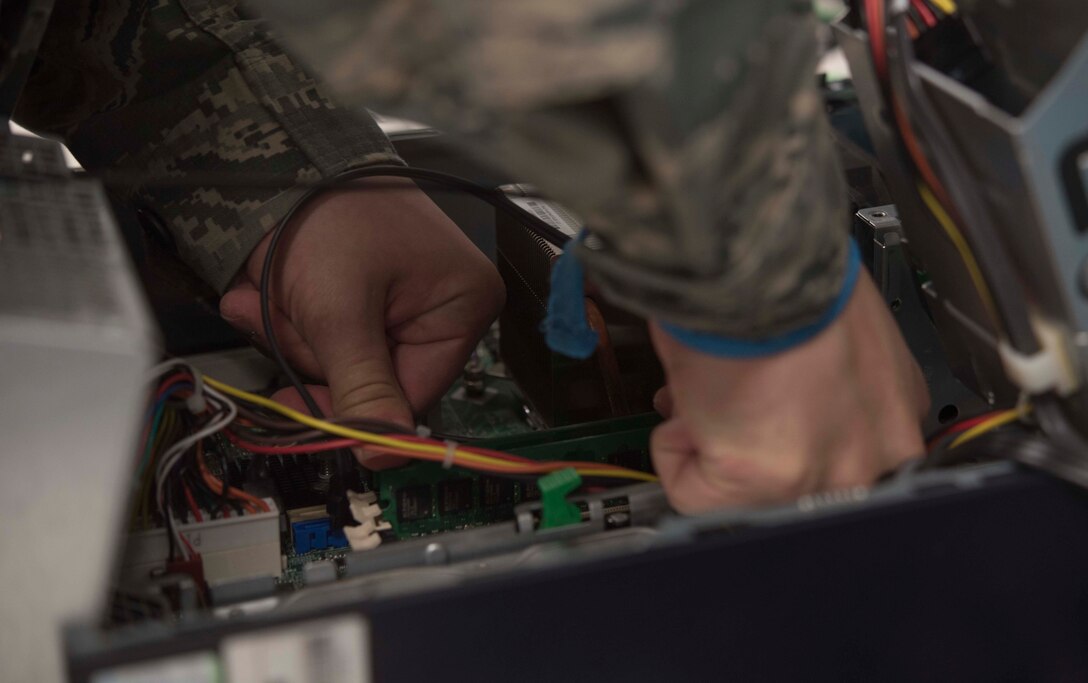U.S. Air Force Airman Matthew Kennison, a client systems technician with the 35th Communications Squadron, replaces the hardware of a desktop computer at Misawa Air Base, Japan, Feb. 10, 2016. When a computer needs a repair, client system technicians are called to solve various problems beginning with reimaging, which removes all software on a computer then reinstalls everything. If the problem isn’t resolved, the next step is to troubleshoot and possibly replace the hard drive, graphics card and random access memory.  (U.S. Air Force photo by Airman 1st Class Jordyn Fetter)