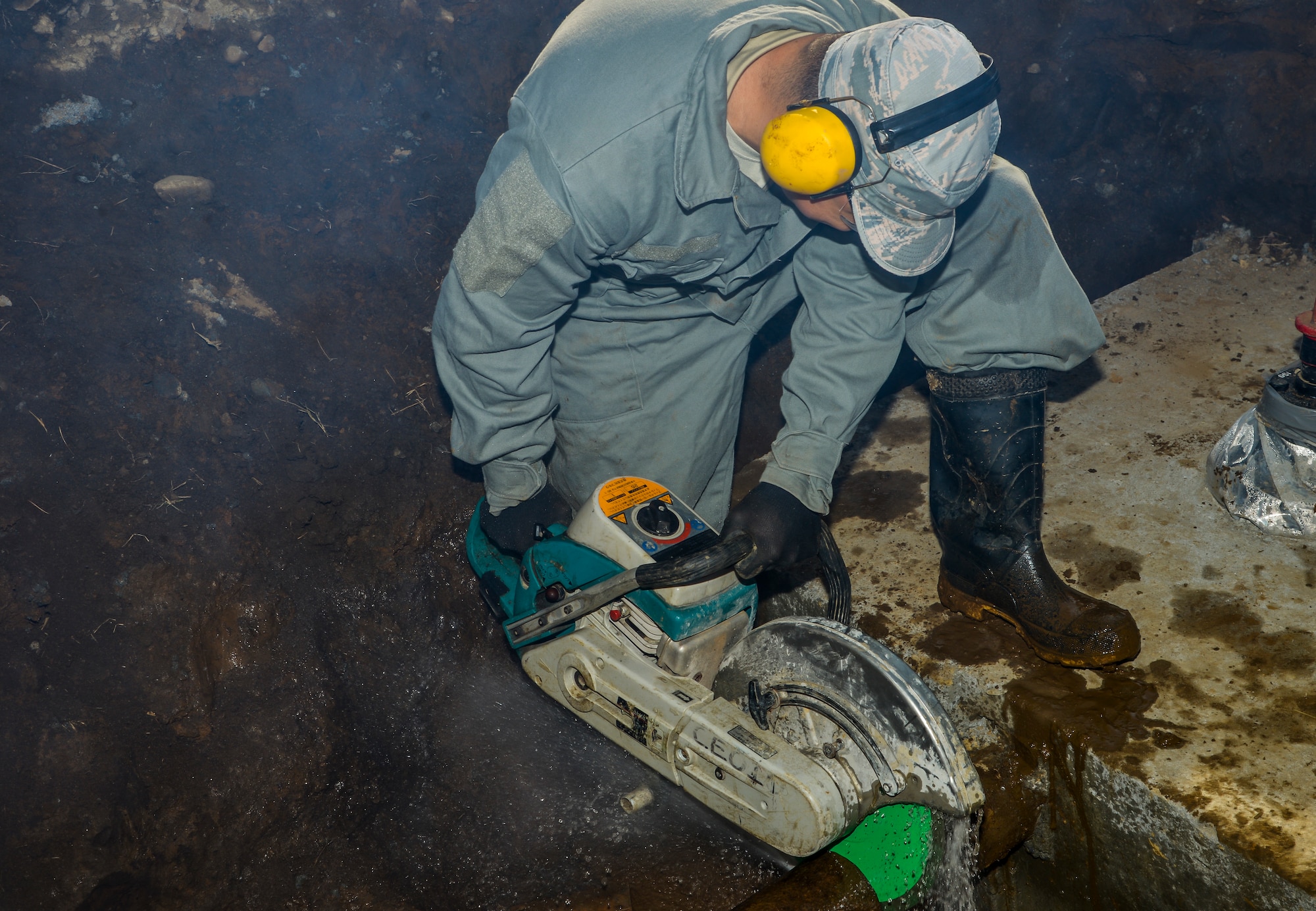 Staff Sgt. Leeroy Bocanegra, 374th Civil Engineer Squadron water fuel system maintenance craftsman, cuts a metal pipe with a K-12 cutting saw at Yokota Air Base, Japan, Feb. 9, 2016. The saw allowed the Airmen to place a new pipe with two Hymax mechanical coup links on the pipeline. (U.S. Air Force photo by Senior Airman David Owsianka/Released)