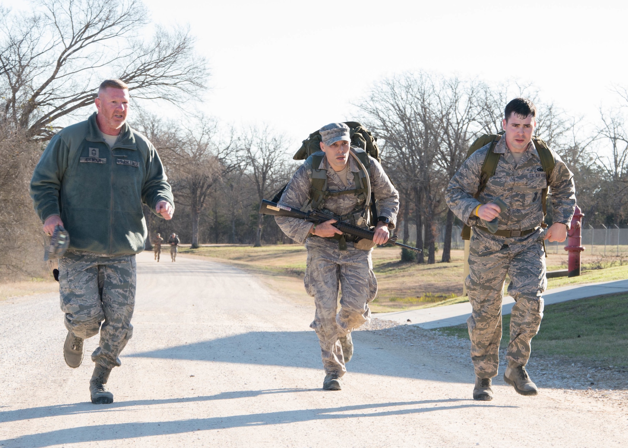 U.S. Air Force Staff Sgt. Steven Hein, an Air National Guard competitor, along with U.S. Air Force Chief Master Sgt. Del Atkinson and Tech. Sgt. Timothy Rooney, all from the 136th Security Forces Squadron, race to the end of an eight-mile ruck march during the Best Warrior Competition at Camp Swift, Texas, Feb. 6, 2015. The BWC test the aptitude of elite Texas Air and Army National Guardsmen in events relevant to today's operating environment. (Texas Air National Guard photo by Tech. Sgt. Vanessa Reed/ Released)