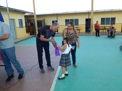 Comayagua, Honduras – Sgt. Maj. Francisco Ramos, Joint Security Forces Command Sergeant Major, gives school materials to a girl in CasAyuda, Comayagua, Honduras, Feb. 02, 2016, during an activity sponsored by Joint Task Force-Bravo Joint Security Forces volunteers. The unit provided backpacks, notebooks and pencils for the children and also participates in monthly visits to the special needs school. (U.S. Army photo by Spc. Audie Colón)