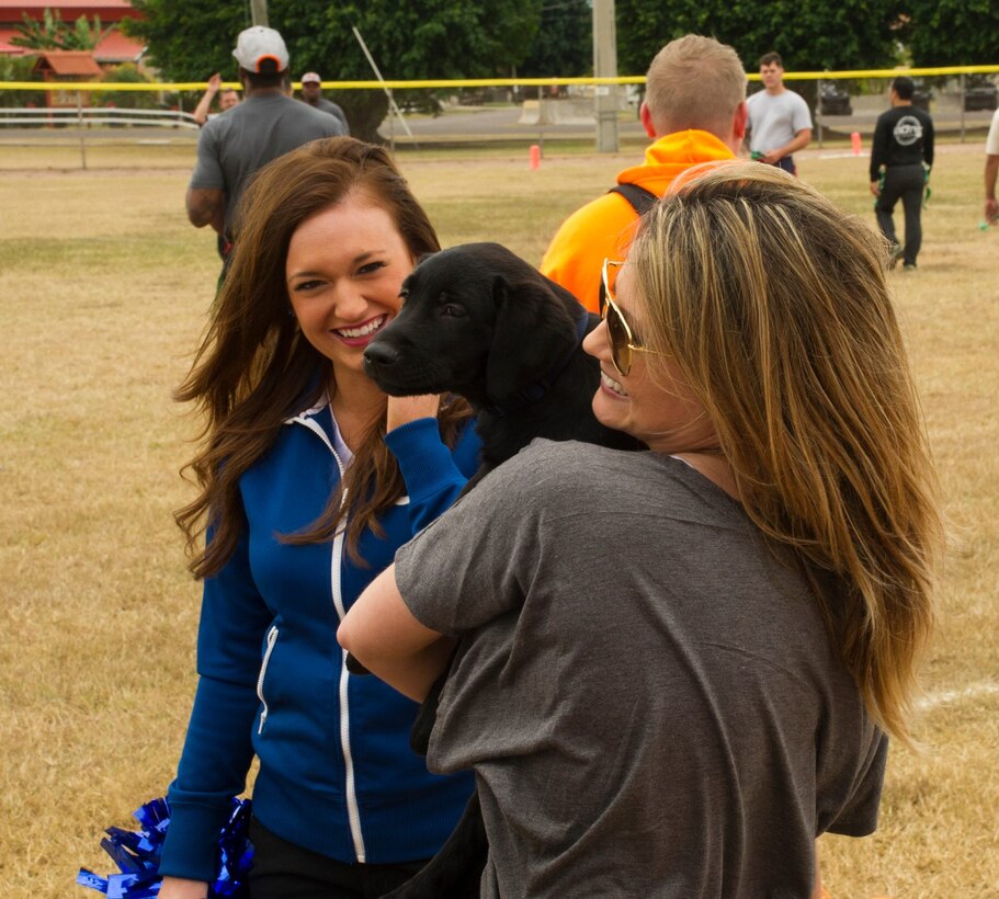 From left, Cassia Gass, Indianapolis Colts cheerleader and Amanda Golden play with the new 612th Air Base Squadron mascot during a flag football match Feb. 6, 2016 at Soto Cano Air Base, Honduras, involving members of Joint Task Force-Bravo and NFL players. (U.S. Air Force photo by Capt. Christopher Mesnard/Released)