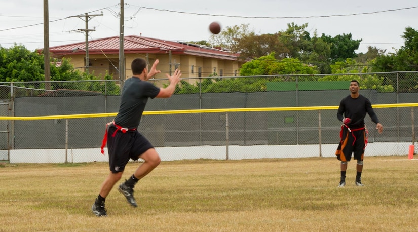 U.S. Air Force Master Sgt. Philip Rush, 612th Air Base Squadron Air Traffic Control and Landing System section chief passes a ball to U.S. Air Force 1st Lt. Benjamin Kopacka, 612th Air Base Squadron chief of engineering during a flag football game Feb. 6, 2016 at Soto Cano Air Base, Honduras, as a part of an NFL player and cheerleader visit with the Armed Forces Entertainment organization for Super Bowl 50. (U.S. Air Force photo by Capt. Christopher Mesnard/Released)