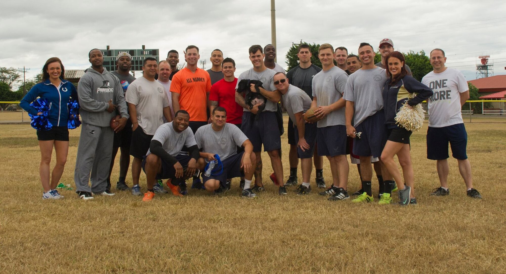 Servicemembers with the 612th Air Base Squadron at Soto Cano Air Base, Honduras, pose for a photo with NFL players and cheerleaders after a game of flag football Feb. 6, 2016, as a part of a visit to the base hosted by the Armed Forces Entertainment for Super Bowl 50. (U.S. Air Force photo by Capt. Christopher Mesnard/Released)
