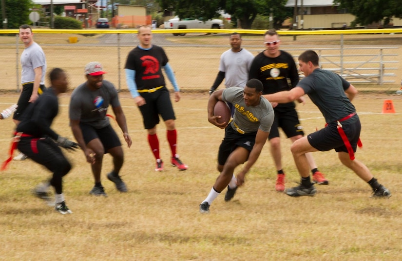 A Servicemember with the Army Forces Battalion at Soto Cano Air Base, Honduras, runs the ball during a game of flag football Feb. 6, 2016, as a part of a NFL player and cheerleader visit to the base hosted by the Armed Forces Entertainment for Super Bowl 50. (U.S. Air Force photo by Capt. Christopher Mesnard/Released)