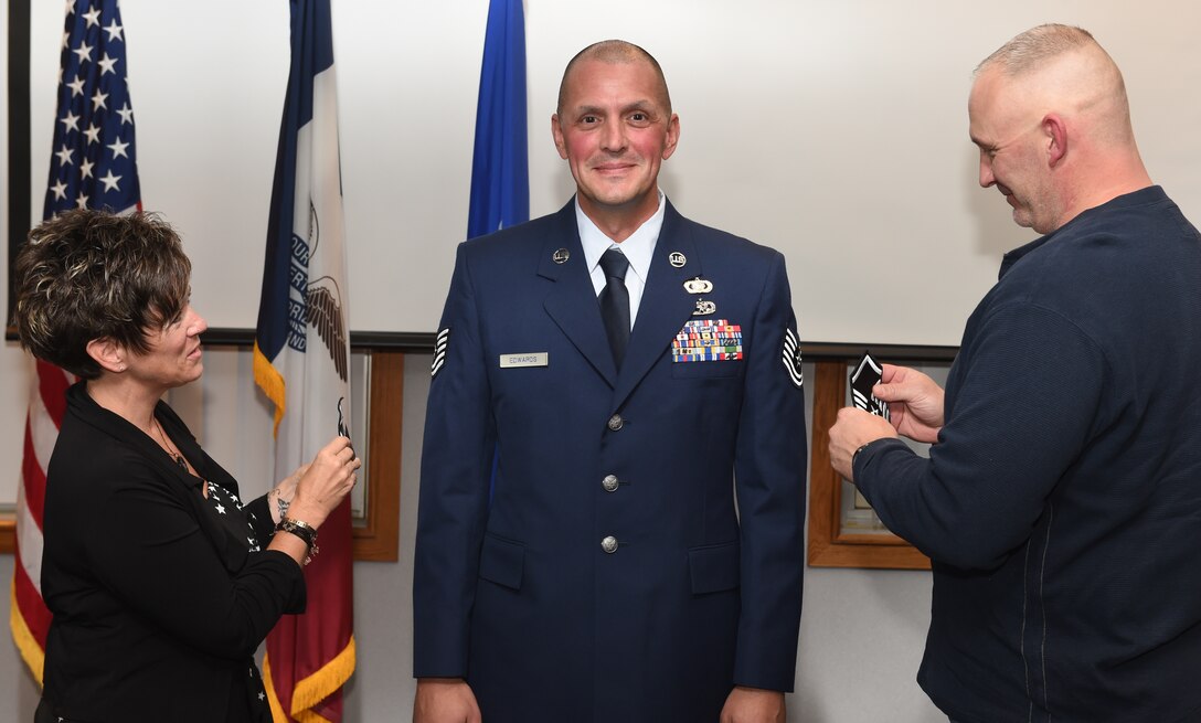 Tech. Sgt. Steven Edwards is promoted to the rank of Master Sgt at the 132d Wing Classroom, getting some help putting on his new stripes. (U.S. Air National Guard photo by Staff Sgt. Matthew T. Doyle/Released)