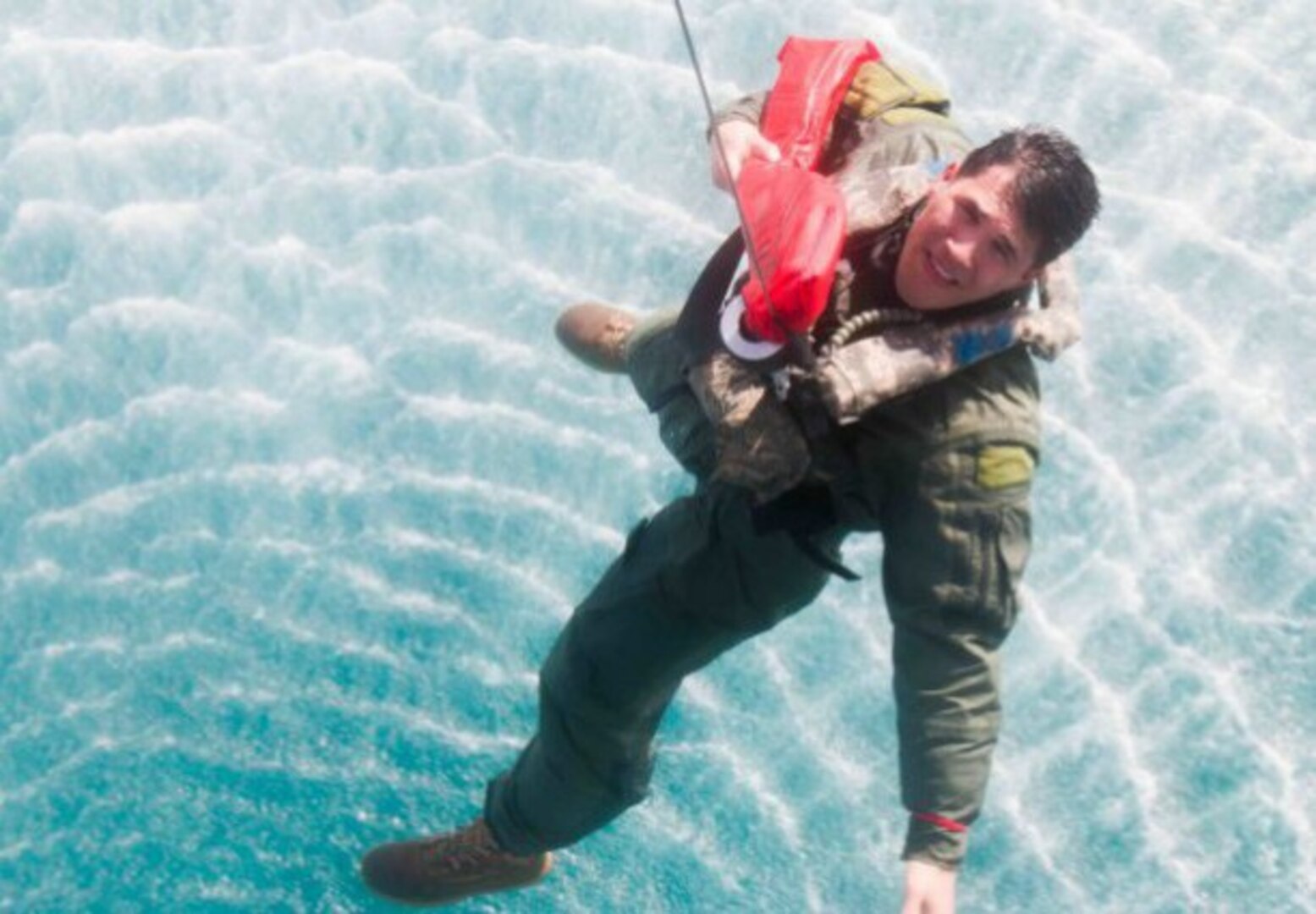 California Army National Guard Sgt. Nathan Wong looks up as he is hoisted into a Navy MH-60 Seahawk helicopter with Helicopter Sea Combat Squadron 26 during a search and rescue exercise in the Arabian Gulf, Feb. 2. (U.S. Army photo by Staff Sgt. Ian Kummer)