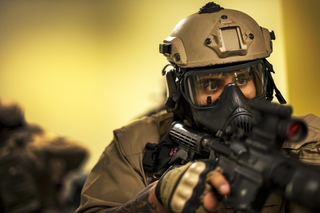 Air Force Staff Sgt. Israel Garza secures a hallway as his team members clear a room at the youth center during a training exercise on Moody Air Force Base, Ga., Jan. 28, 2016. Garza is a unit trainer with the 23rd Security Forces Squadron. Air Force photo by Tech. Sgt. Zachary Wolf