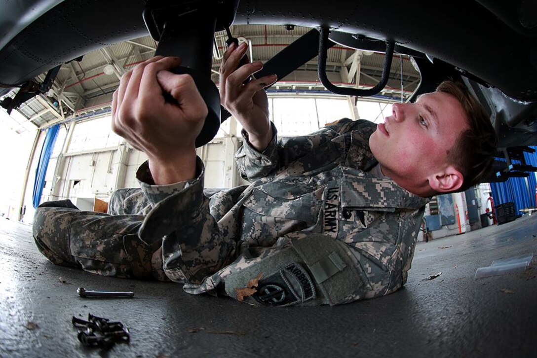 A soldier prepares an AH-64 Apache helicopter for transport on Fort Bragg, N.C., Feb. 2, 2016. Army photo by Staff Sgt. Christopher Freeman
