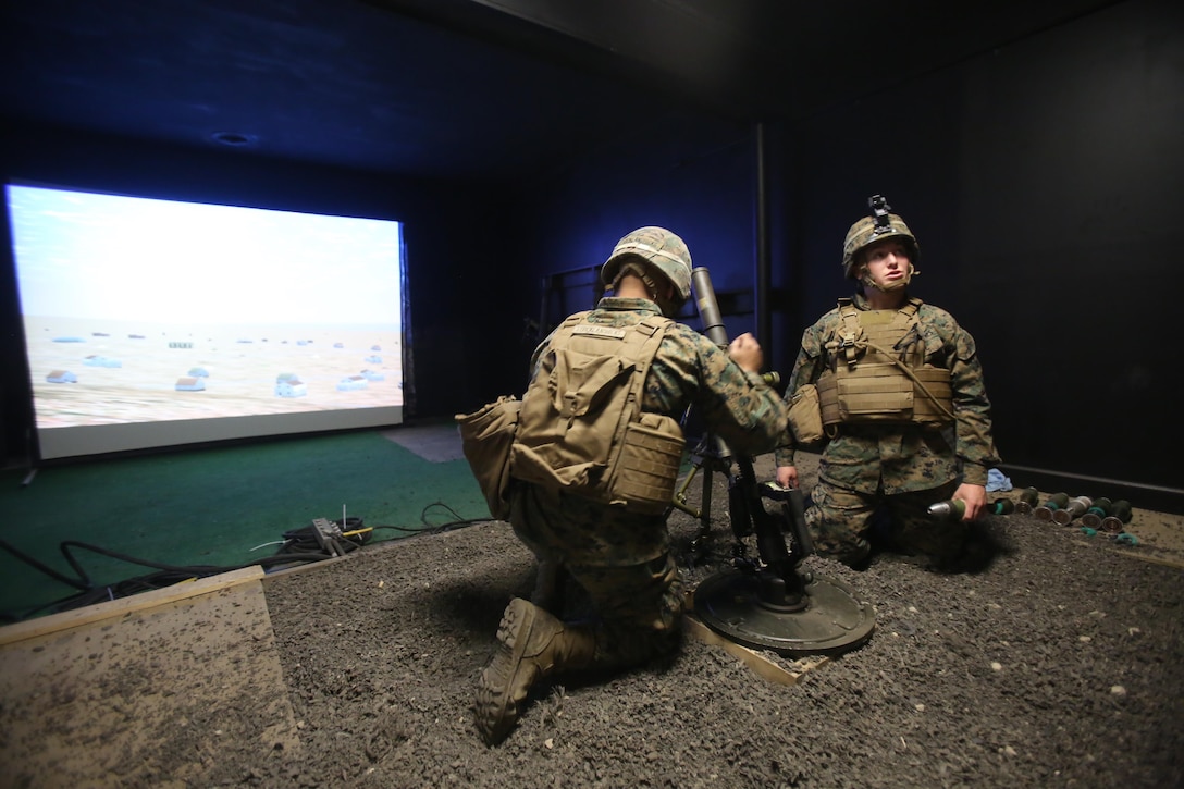 Two Marines conduct simulated mortar fires while training with the Division Combat Skills Center in the Indoor Simulated Marksmanship Trainer at Camp Lejeune, N.C., Jan. 27, 2016. This simulated motorman’s pit provides a safer and more accurate way of honing their skills before firing live rounds. (U.S. Marine Corps photo by Cpl. Chelsea Toombs/Released)