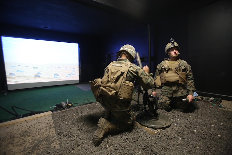 Two Marines conduct simulated mortar fires while training with the Division Combat Skills Center in the Indoor Simulated Marksmanship Trainer at Camp Lejeune, N.C., Jan. 27, 2016. This simulated motorman’s pit provides a safer and more accurate way of honing their skills before firing live rounds. (U.S. Marine Corps photo by Cpl. Chelsea Toombs/Released)