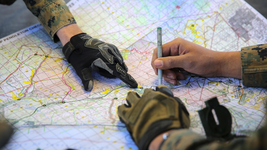 Marines plot objective points on a map to reach during a combat endurance challenge Marine Corps Base Camp Pendleton, Calif. Feb. 5, 2016. The challenge consisted of hiking nearly seven miles, testing weapons systems, combat lifesaving skills, land navigation and simulated casualty evacuation. The Marines with Battery Q, 5th Battalion, 11th Marine Regiment conducted the training aboard MCB Camp Pendleton. 