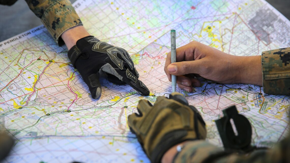 Marines plot objective points on a map to reach during a combat endurance challenge Marine Corps Base Camp Pendleton, Calif. Feb. 5, 2016. The challenge consisted of hiking nearly seven miles, testing weapons systems, combat lifesaving skills, land navigation and simulated casualty evacuation. The Marines with Battery Q, 5th Battalion, 11th Marine Regiment conducted the training aboard MCB Camp Pendleton. 