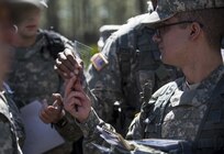 U.S. Army Reserve Soldiers pass along protractors to one another on a land navigation course in this year's 200th Military Police Command's Best Warrior Competition held at Camp Blanding, Fla., Feb. 9. The winning noncommissioned officer and junior enlisted Soldiers will move on to the U.S. Army Reserve Command competition in May. (U.S. Army photo by Master Sgt. Michel Sauret)
