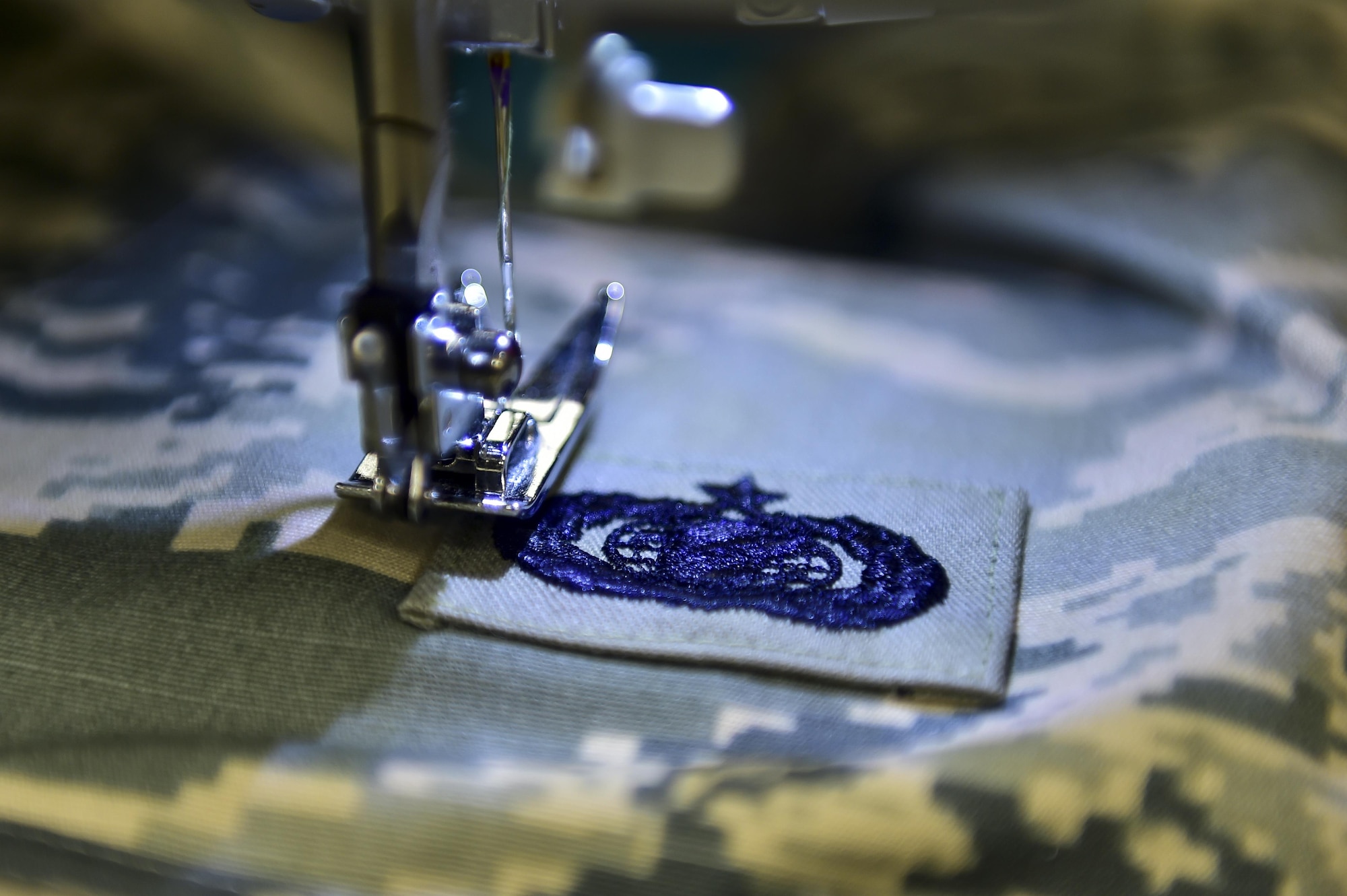 An occupational badge is sewn on during a Munch 'n Mend at the chapel, Hurlburt Field, Fla., on Feb. 8, 2016. Munch 'n Mend is a chapel-hosted program held the second Monday of every month. The program is for all Airmen, enlisted and officer, to take their uniforms to have stripes, name tapes and other alterations done, and enjoy a home-cooked meal, free of charge. (U.S. Air Force photo by Senior Airman Jeff Parkinson)