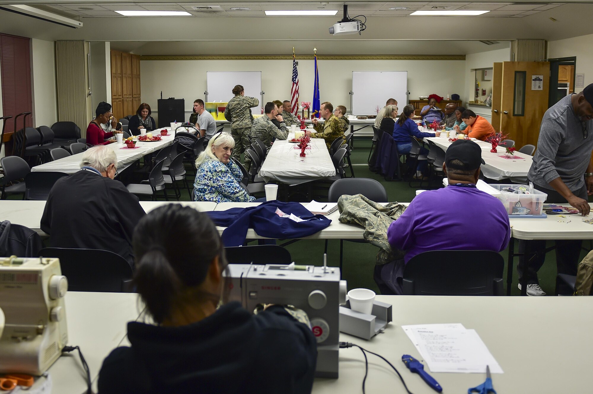 Members and their familes enjoy a home-cooked meal while they have stripes, name tapes and other alterations made to their uniforms during a Munch 'n Mend at chapel, Hurlburt Field, Fla., on Feb. 8, 2016. Munch 'n Mend is a monthly chapel event which allows the chapel staff and its volunteers to give back to their Hurlburt Field community. (U.S. Air Force photo by Senior Airman Jeff Parkinson)