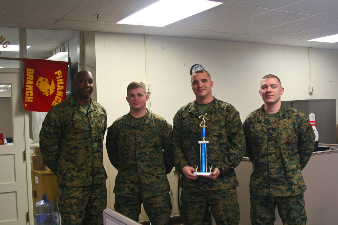 Sgt. Major Gerald Saunders, PFC. Aeron Britt, Sgt. Taylor Sams and Sgt. Alex Washington pose Feb. 2 with the trophy awarded to Team Finance, winners of "MCB Quantico's Sergeant Major Bowling Challenge." The challenge, hosted by Saunders, was for sergeants and below.