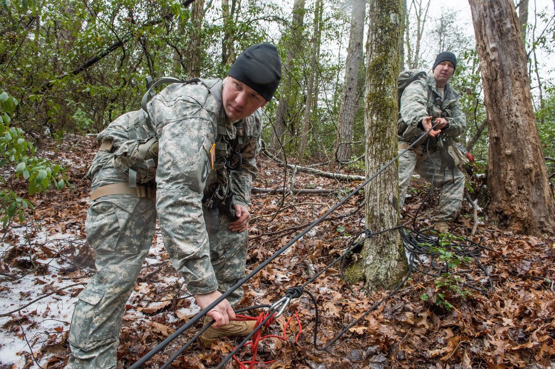 U.S. Army Staff Sgts. Seth Monroe (front) and Chism Michels (rear), both assigned to 5th Ranger Training Battalion, hoist a simulated patient during the Basic Military Mountaineering Course at Camp Frank D. Merrill, Dahlonega, Ga., Jan. 21, 2016. The Basic Military Mountaineering Course trains Soldiers in the fundamental knowledge/skills required to successfully conduct small unit operations in mountainous terrain found throughout the world. (U.S. Army photo by Staff Sgt. Alex Manne/Released)