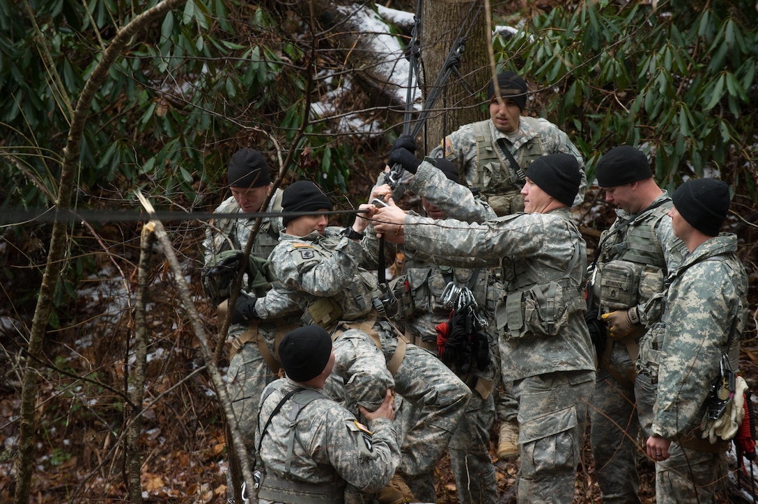 U.S. Army soldiers assigned to 5th Ranger Training Battalion attempt to cross a rope bridge over the Etowah River during the Basic Military Mountaineering Course at Camp Frank D. Merrill, Dahlonega, Ga., Jan. 21, 2016. The rope bridge is a "tight rope” or high load installation used to move personnel and equipment over terrain obstacles such as swift flowing mountain streams, ravines, and other deep gullies. (U.S. Army photo by Staff Sgt. Alex Manne/Released)