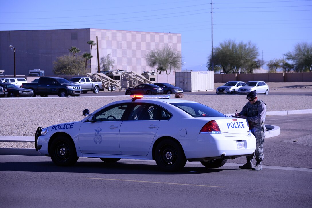 Master Sgt. Sean Nichols, 56th Security Forces Squadron alpha flight chief, writes a traffic citation for texting while driving Feb. 9 at Luke Air Base. Airmen in the 56th SFS make between 10 to 15 traffic stops on base daily. The majority of traffic stops are due to motorists failing to stop at a stop sign and talking on the phone while driving.
