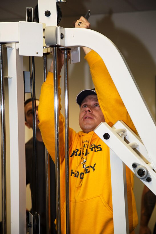 Staff Sgt. Frank Kovach, tightens a bolt during the reassembly of a universal gym that will be part of the exercise equipment used by the residents of the Veterans Home Of California-Barstow. Kovach along with several other Marines, a Sailor, dependents, volunteered to set up an in-house gym for the veterans, Feb. 6.