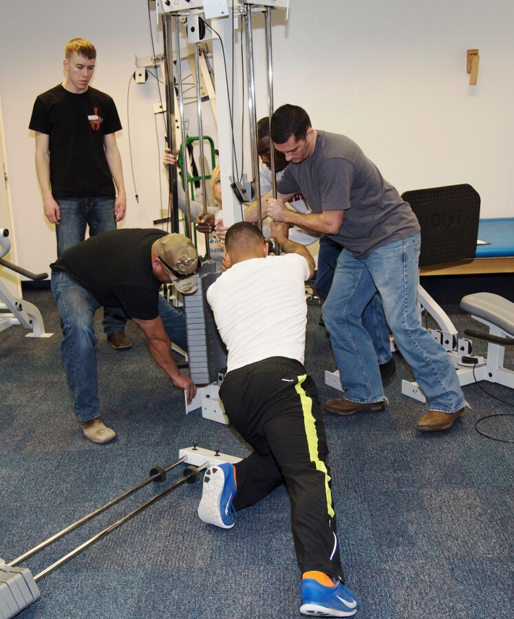 Personnel from MCLB Barstow try to move the main fixture of a universal gym to its designated spot in the in-house gym for the Veterans Home of California-Barstow. Fourteen members - Marines, a Sailor, and dependents - gave up their Saturday morning, Feb.6, to set up the gym for the residents.