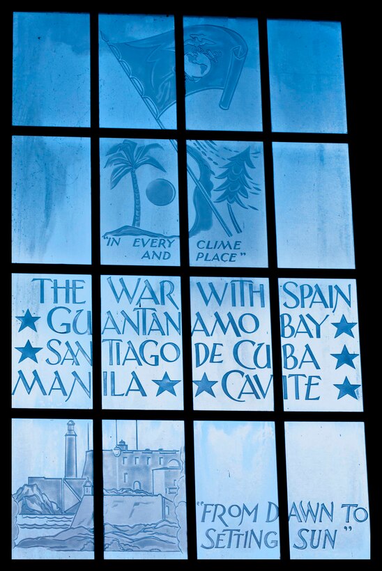 This upper portion of a window depicts a palm tree and an evergreen tree, symbolizing the extreme climates in which Marines have fought.