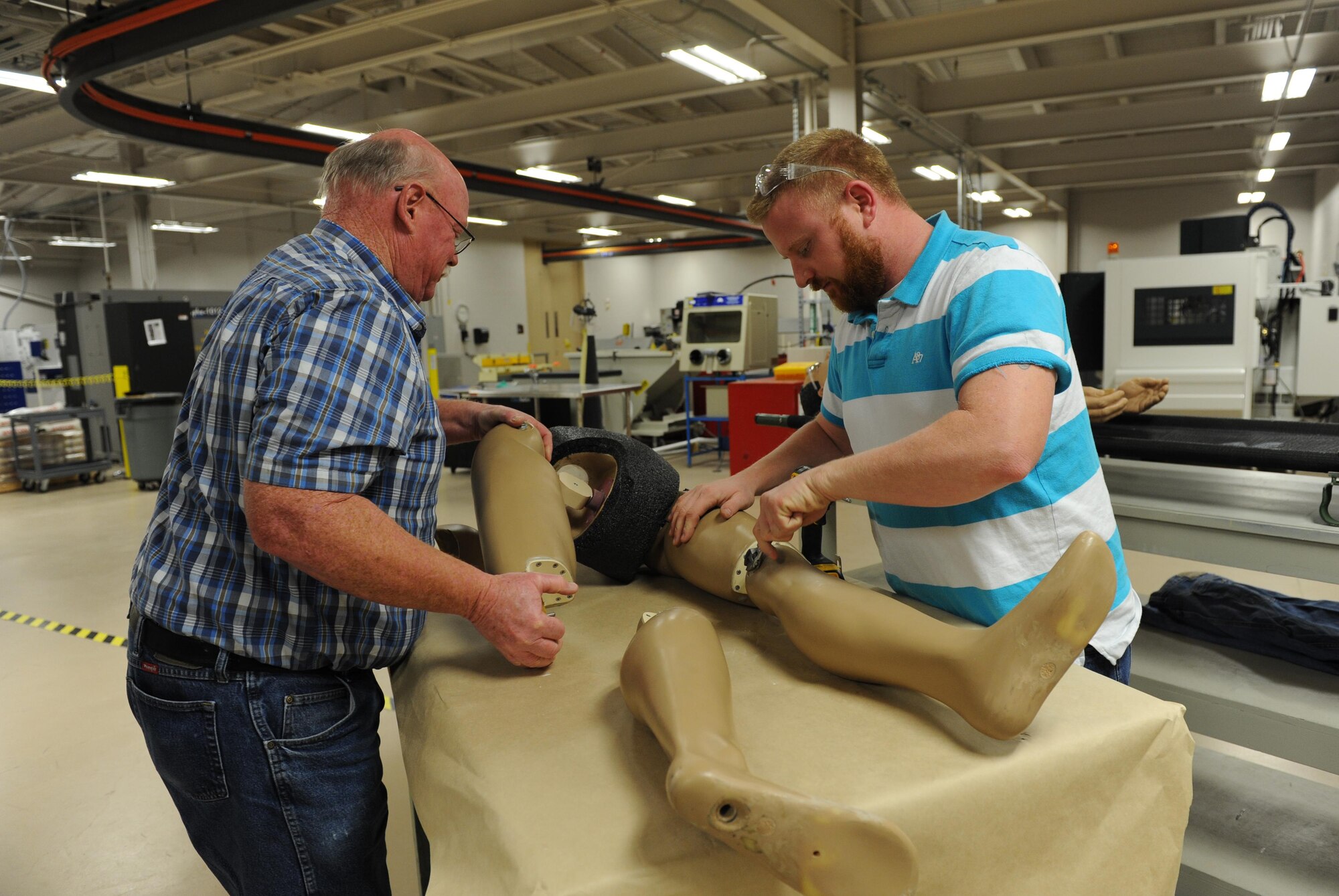 Tom Capers, 81st Training Support Squadron machinist and welder, and James McCanless, 81st TRSS sheet metal technician, assemble mannequin pieces at the Trainer Development Center Feb. 8, 2016, Keesler Air Force Base, Miss. The 81st TRSS manufactured two lower torso mannequins for the 81st Medical Group to be used for training. By manufacturing the training mannequin in-house, the 81st TRSS saved the Air Force an estimated $21,000. (U.S. Air Force photo by Kemberly Groue)