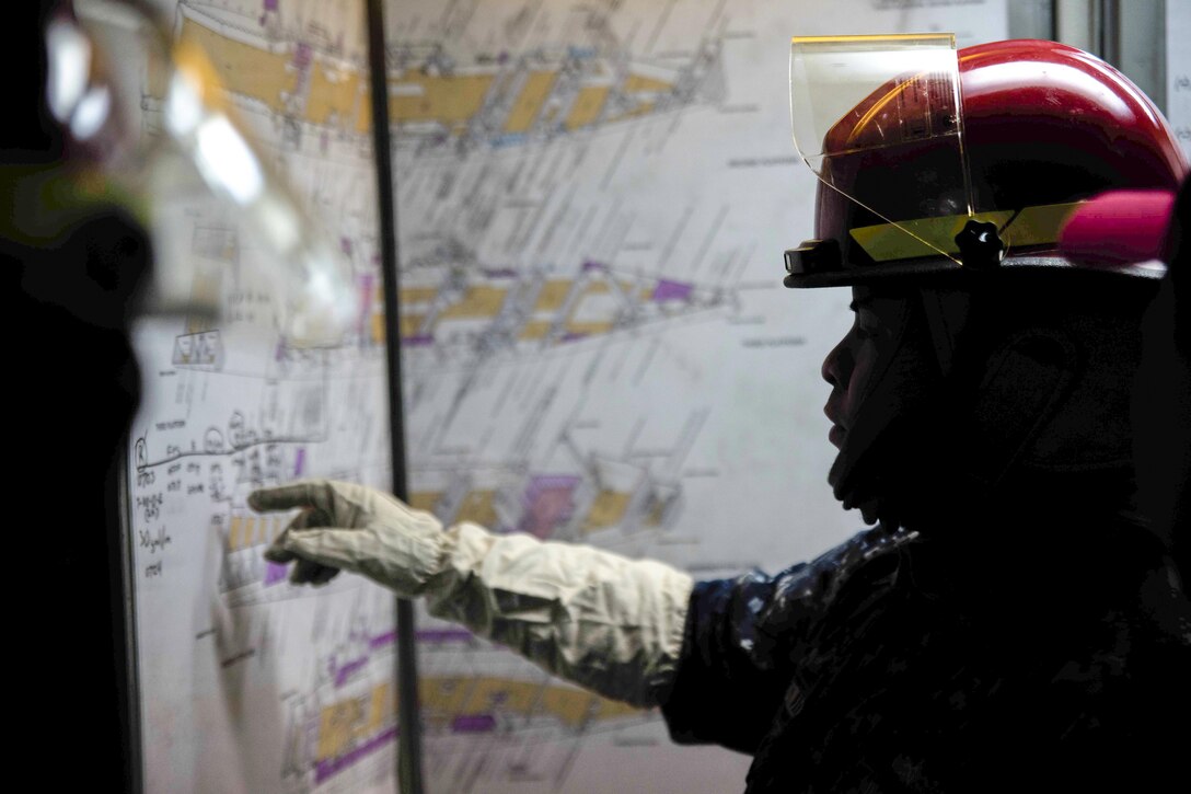 U.S. Navy Petty Officer 2nd Class Robert Castillo checks a damage control board during a fire drill on the USS Green Bay near Sasebo, Japan, Feb. 11, 2016. The Bay is attached to the Bonhomme Richard Amphibious Ready Group. Navy photo by Petty Officer 2nd Class Chris Williamson