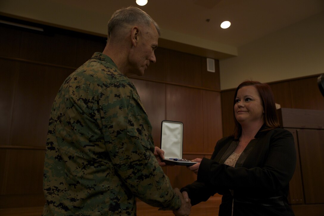 Lt. Gen. Rex C. McMillian, commander of Marine Forces Reserve, presents Lauren C. Yaw, muster program lead for Marine Corps Individual Reserve Support Activity, the 2015 Marine Forces Reserve junior Civilian of the Year award, Feb. 5, 2016, at Marine Corps Support Facility New Orleans. Yaw went above and beyond her everyday job duties, and was recognized for her hard work. (U.S. Marine Corps photo Lance Cpl. Melissa Martens/ Released)
