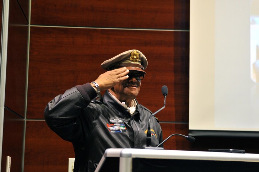 Donning an authentic Tuskegee Airmen cap, ‘Uncle’ Ron Spriggs salutes following his speech about the Tuskegee Airmen during the 63rd Regional Support Command’s Black History Month Celebration, Feb. 10, in the headquarters auditorium, Mountain View, Calif. Spriggs is an Air Force veteran and founder of the Ron Spriggs Exhibit of Tuskegee Airmen (RSETA), and tours the nation teaching the history of the famous airmen, the first black aviators in U.S. military history during World War II.