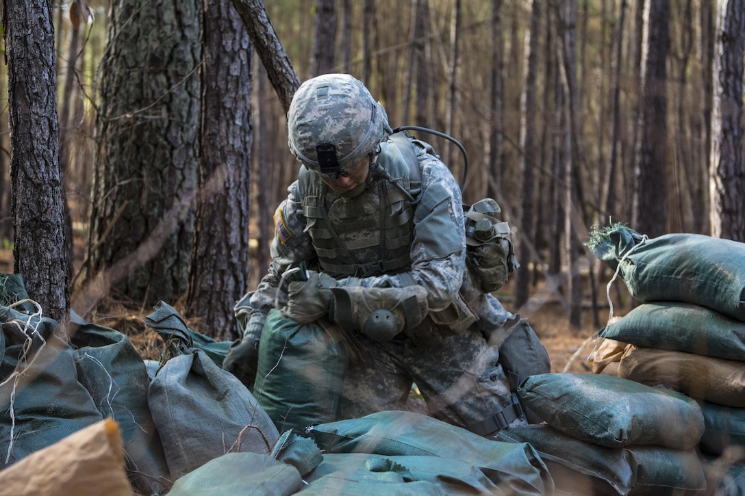 Army Reserve Soldier, Pvt. Melissa Stamey, C Company, 1st Battalion, 61st Infantry Regiment, works to rebuild her firing position after the wall of sandbags around her M249 light machine gun collapsed during the Victory Forge field training exercise at Fort Jackson, S.C., Feb. 10, 2016. Victory Forge is the culminating event just before graduation for Soldiers at Fort Jackson in Basic Combat Training. Stamey will head to Fort Lee, Va. after basic where she will attend Advanced Individual Training as a supply specialist. (U.S. Army photo by Sgt. 1st Class Brian Hamilton)
